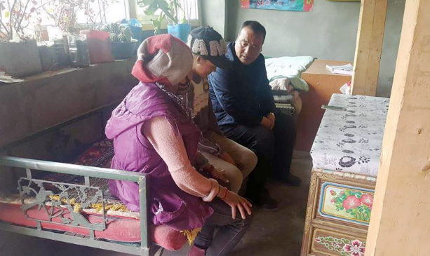 　　慕育军（右）在结对帮扶的扎囊县藏族群众家里了解情况（摄于2017年1月）。