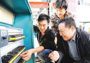 范振喜(右)在向技术员了解新设备的安装情况。(资料图)