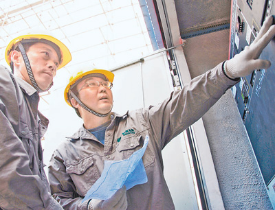 张黎明（右）在认真地开展线路故障检修工作。（资料照片）