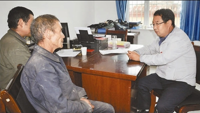 李培东（右一）在与党员们谈心。资料照片