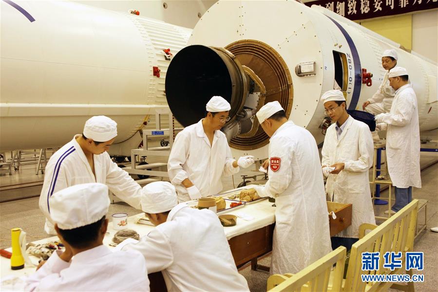 在西昌卫星发射中心总装车间,科研人员正在安装火工品(2009年8月11日摄)。新华社发(航天科技集团第一研究院供图)