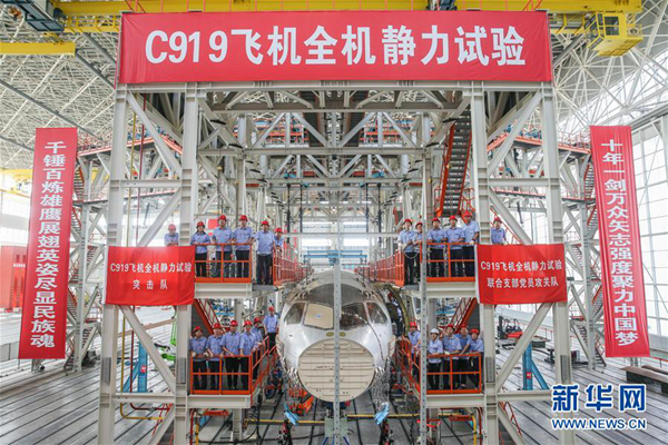 在位于上海浦东机场区域的中国航空工业飞机强度研究所内,工作人员在C919大型客机10001验证飞机的工作平台上合影(6月21日摄)。新华社记者 丁汀 摄