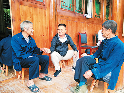 杨平(中)与村民沟通交流。(资料图片)