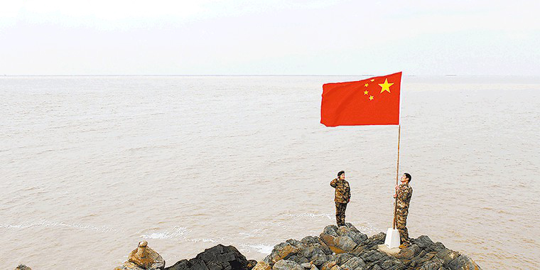 图为王继才生前与妻子一起升国旗的情景,一人升旗,一人敬礼,没有国歌,没有奏乐,却庄严肃穆。