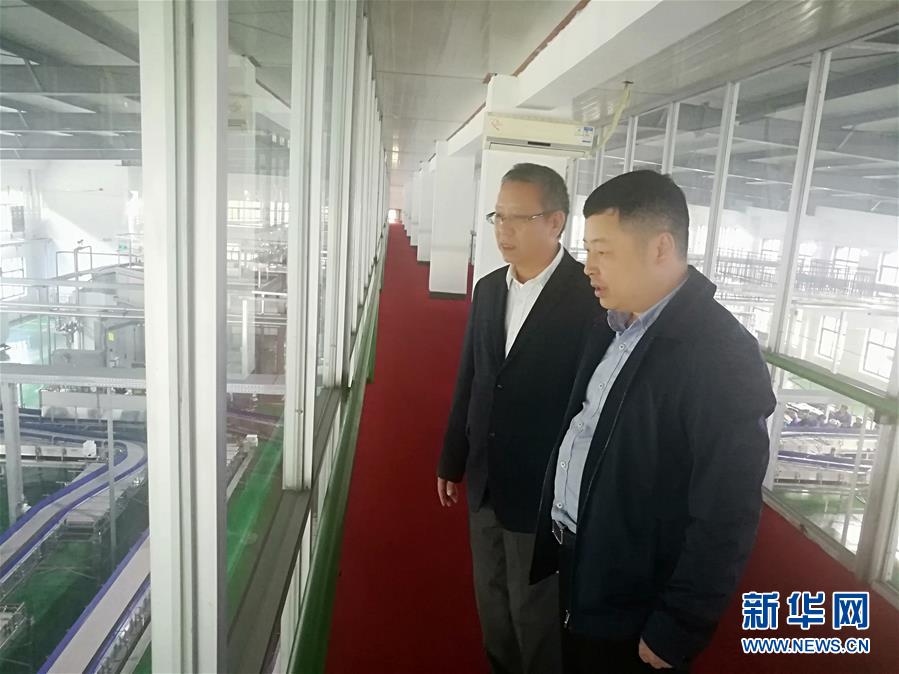 何张辉(右)在饮用水企业调研问需