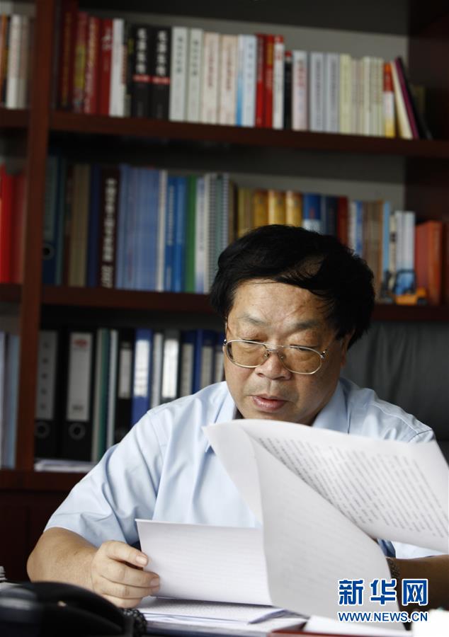 包起帆在审阅公司业务报表(2009年9月15日摄)。