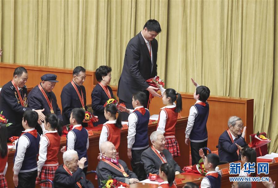 在北京举行的庆祝改革开放40周年大会上，姚明（上）接受少先队员献花（2018年12月18日摄）。新华社记者 殷刚 摄