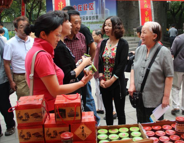 产品进社区,张莉华(右二)为顾客介绍产品。