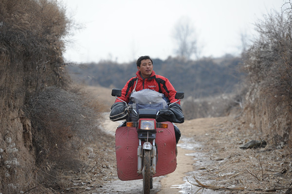 贺星龙骑着摩托车出诊