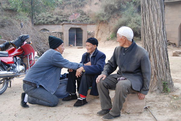 贺星龙在村头给村民看病