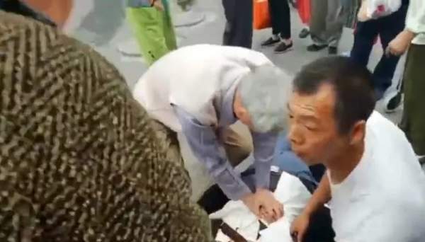 图为于守堤老人为病人进行心肺按压