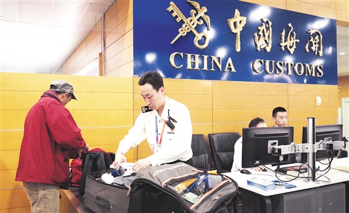 周琰(右)正在开箱检查旅客行李。 (资料图片)